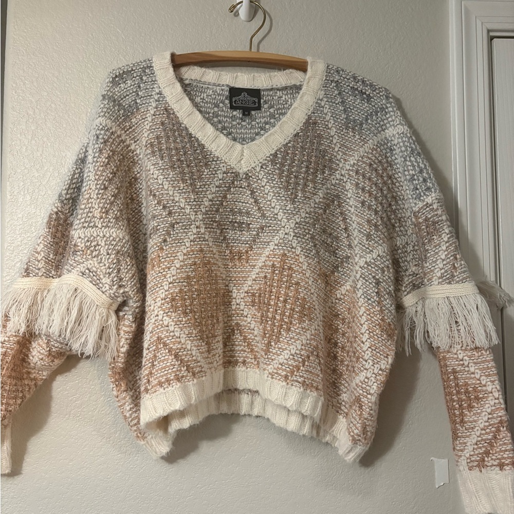 Cute V neck diamond pattern sweater with fringe on‎ sleeves. Muted colors